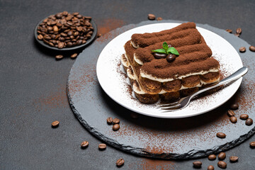 Classic tiramisu dessert on ceramic plate on concrete background
