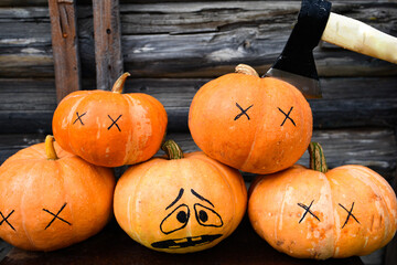 halloween concept. Pile of pumpkins with an ax for chopping. Horror scene of the group of dead pumpkins