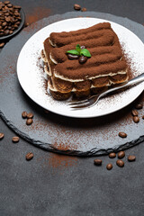 Classic tiramisu dessert on ceramic plate on concrete background