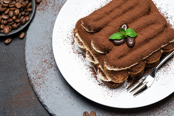 Classic tiramisu dessert on ceramic plate on concrete background