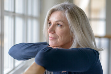 Attractive blond woman standing daydreaming