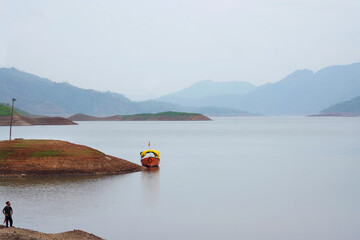 A Boy Standing at Beautiful Lake Surrounded by Mountains. Lake, Boat and Mountains