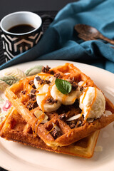 Food meal Breakfast concept Homemade organic Waffles banana vanilla ice-cream topping with caramel sauce on black background with copy space