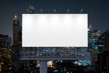 Obraz premium Blank white road billboard with Bangkok cityscape background at night time. Street advertising poster, mock up, 3D rendering. Front view. The concept of marketing communication to promote idea.
