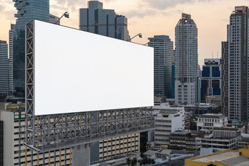 Blank white road billboard with Bangkok cityscape background at sunset. Street advertising poster, mock up, 3D rendering. Side view. The concept of marketing communication to promote or sell idea.