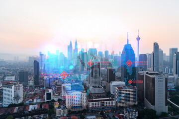 Fototapeta premium Glowing hologram of Earth planet map on aerial panoramic cityscape of Kuala Lumpur at sunset, Malaysia, Asia. The concept of international business in KL. Multi Exposure.