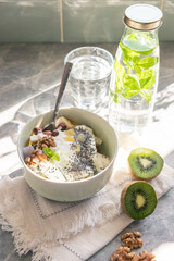 Fruit salad with yogurt in a bowl with. abottle of mint water served for breakfast in sunlight 