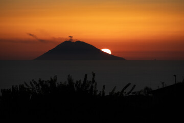 Amazing view of the Stromboli Volcano at sunset, wit the sun going down and amazing sea and sky...