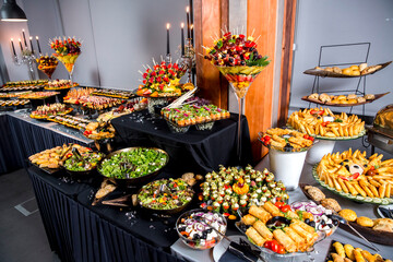 Catering banquet table with various snacks and appetizers with a sandwich