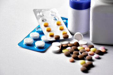 Medicines and bottle on white surface of table.