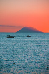 Amazing view of the Stromboli Volcano at sunset, wit the sun going down and amazing sea and sky...