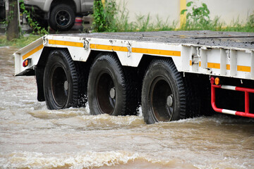 The pickup truck is passing the urban road which fulled of floodwater in the heavy raining day. © Sophon_Nawit