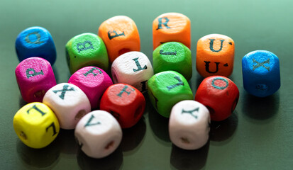 Colored cubes with letters. Multi-colored alphabet macro photography. Wooden elements of the game