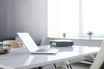 Minimalistic workplace interior in modern office room with laptop on desk, no people shot
