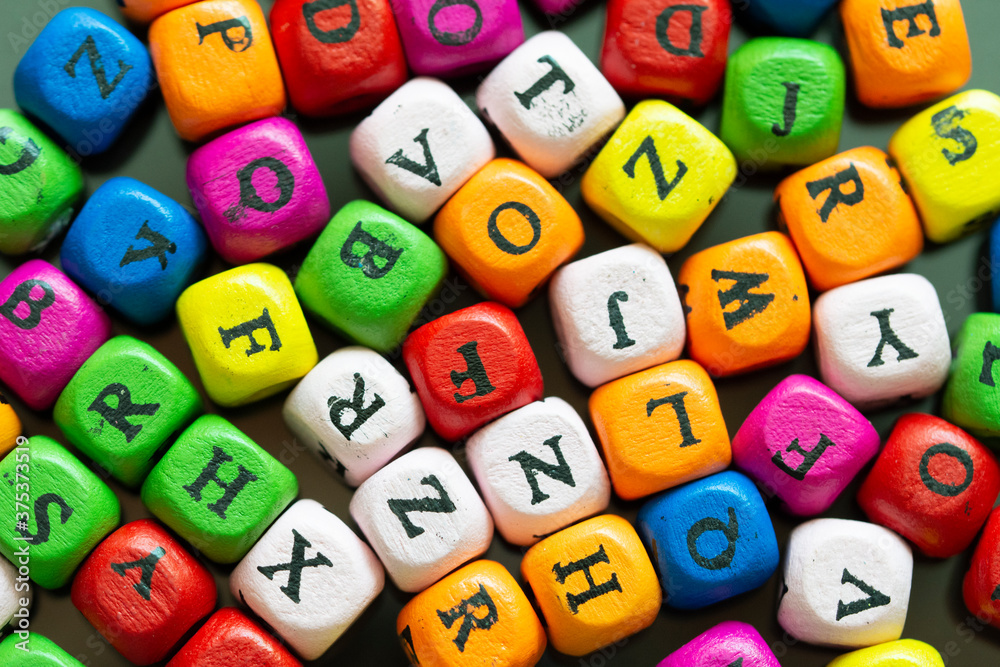 Fototapete colored cubes with letters. multi-colored alphabet macro photography. wooden elements of the game
