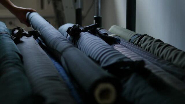 hand pulling fabric roll out of storage, moody lighting