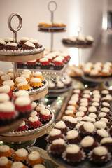 small cupcakes on cake stand in soft light at reception