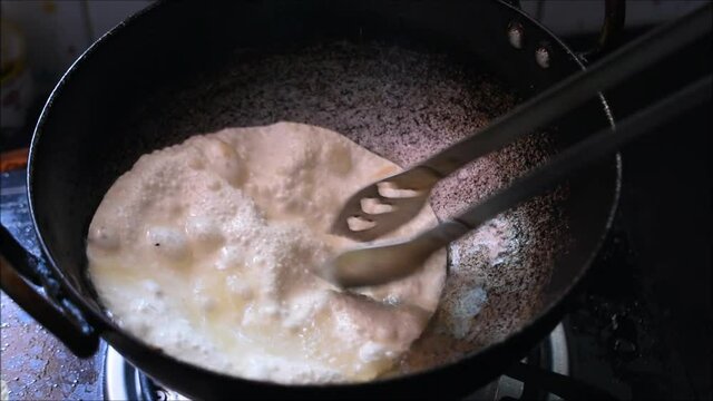 Frying papadam in hot oil.Papadam is a traditional indian snack used as a side dish to main course meal.