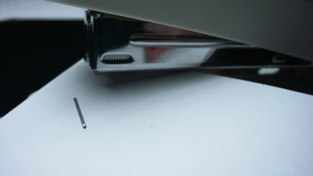 Clerk stapling contract in office. Person fastening documents with stapler