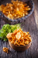 Raw chanterelles mushroom in wooden bowl with parsley herbs
