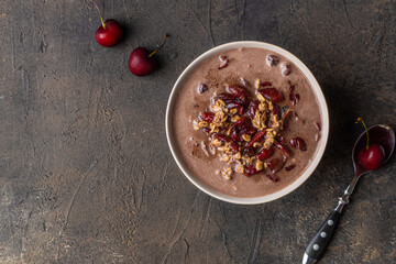 Bowl of cherry porridge oats with grated chocolate. Top view. Copy space