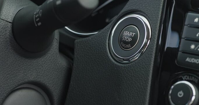 Male hand pushing power button to start keyless ignition hybrid car engine