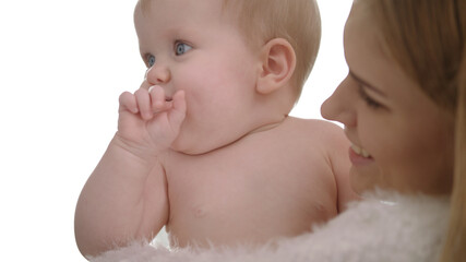 Adorable baby eating finger. Naked child with finger in mouth on mother hands