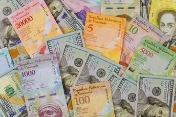 Fototapeta na wymiar American dollar bills notes over Venezuelan Bolivar banknote with paper currency bills.
