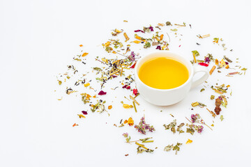 Flat lay layout of cup of green tea with assortment of different dry tea leaf and ginger on white background, copy space for text. Organic herbal, green asian tea for the tea ceremony.