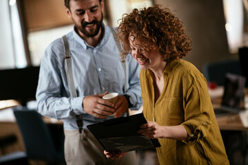 Businesswoman and businessman discussing work in office. Two friends in working together..