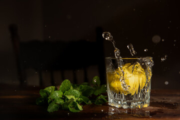 glass of water with lemon splashing into water