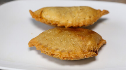 Karipap or "Curry Puff" filled with potato fillings on a white plate