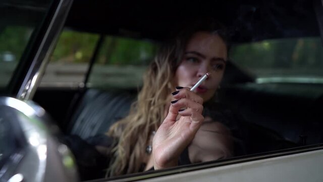 Stress woman in car Smoking cigarettes and talking on speakerphone