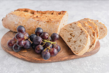 An overhead view of a fresh and crispy cut ciabatta with raisins and grape twigs. Homemade italian bread, bakery
