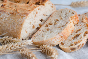 Close-up of a cut homemade ciabatta with raisins and rye ears. Baking, baked goods, bakery