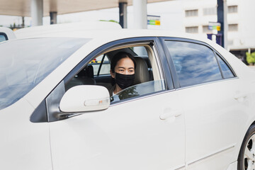 Fototapeta na wymiar Coronavirus pandemic concept woman with protective mask sit in a car road trip travel.