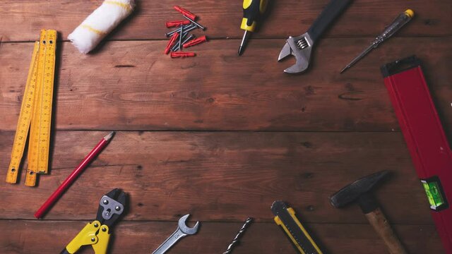 home improvement and repair concept - work tools and objects on wooden table. top view copy space stop motion animation