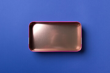 open pink bronze gift box on blue background , top view