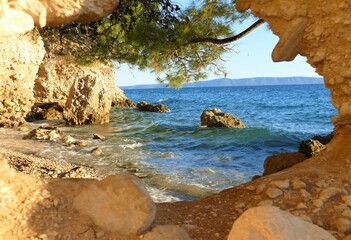 lagoon with cave in the rock with sea view with pine tree and waves