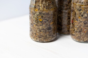 mushroom caviar made of honey mushrooms with tomato and oil in glass pots as preserves