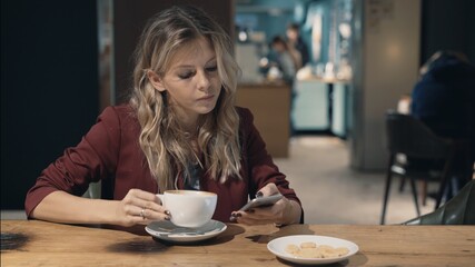 Attractive woman in cafe browsing the Internet using smart phone and waiting some meeting with friend.. High quality photo. Lense flare