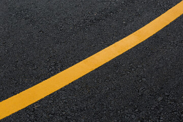 Fototapeta premium Yellow line on asphalt road texture background