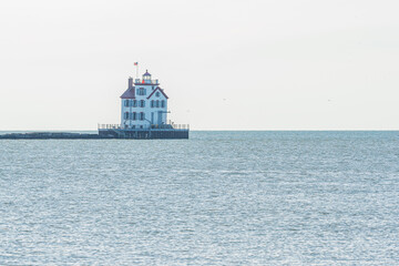 Fototapeta na wymiar Lighthouse in calm water of bay in ocean or lake