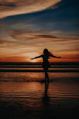 Paradise sunset woman silhouette. Perfect amazing travel destination in Indonesia, Bali, Kuta. Summer vacation concept.