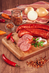 Sliced smoked Calabrese sausage in a wooden table with ingredients