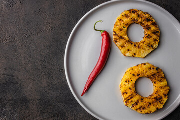 Grilled pineapple slices on plate. Grilled pineapple with chilli. top view copy space