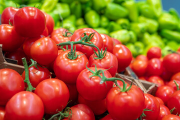 Close-up shot of fresh ripe tomatoes and sweet peppers in modern supermarket
