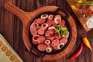 Sliced smoked fried calabrese sausage with onion and beer - Brazilian appetizer top view