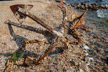 Old unused rusty anchor on the sea shore
