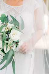 Bride holding a bridal bouquet with green and white flowers